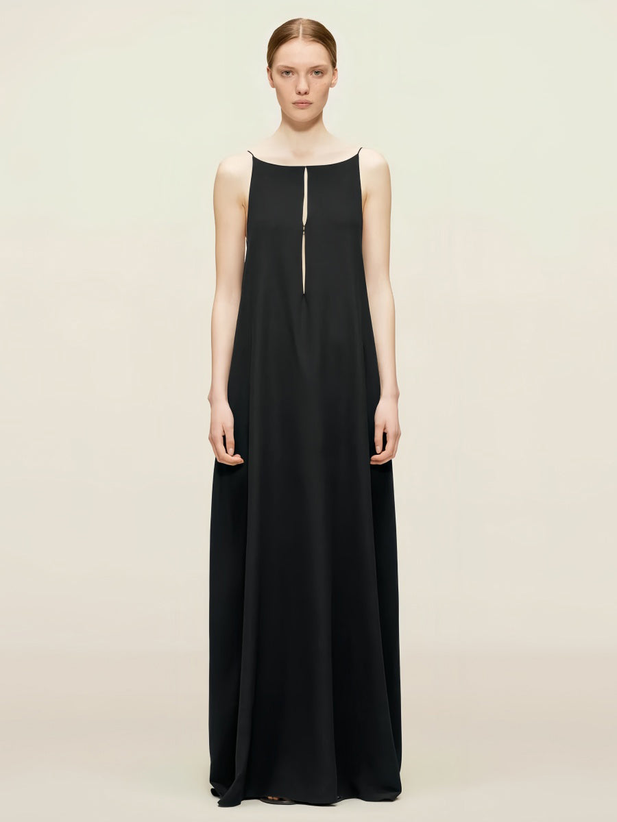 A woman wearing a spaghetti strap, backless, maxi dress in a black color.